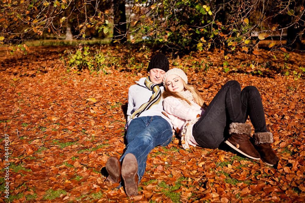 Fototapeta premium Junges Paar im Herbst im park mit bunten blättern im freien