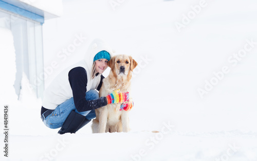 Girl in winter suit on a walk with her labrador. Girl in winter