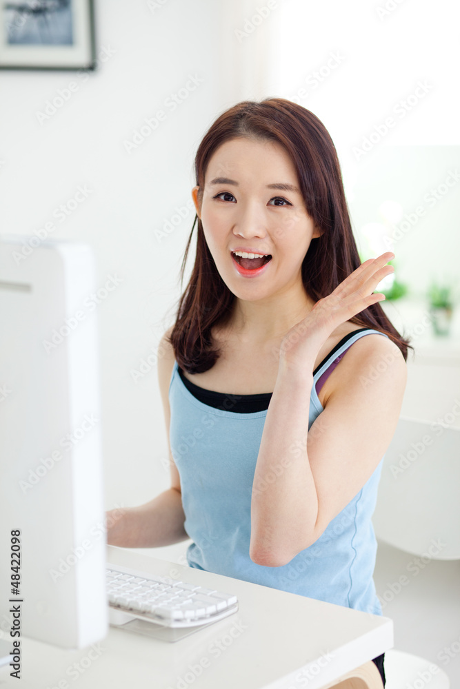 Happy Asian young woman using computer.