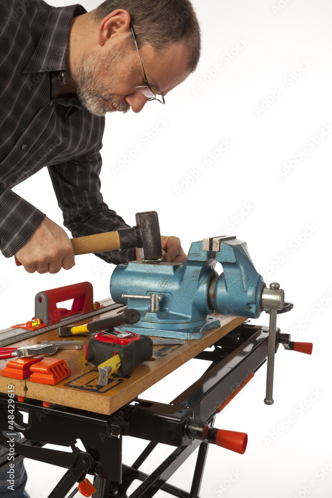 The man with a hammer in a joiner's workshop.