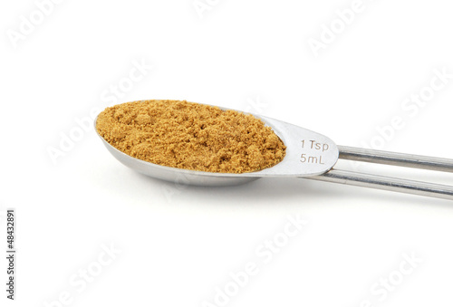 Ground cumin measured in a metal teaspoon