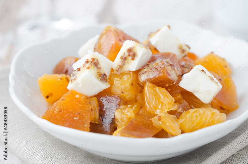 salad with persimmon, mandarin oranges and goat cheese closeup salad with persimmon, mandarin oranges and goat cheese closeup