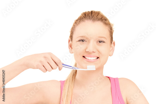 A beautiful blond woman brushing her teeth
