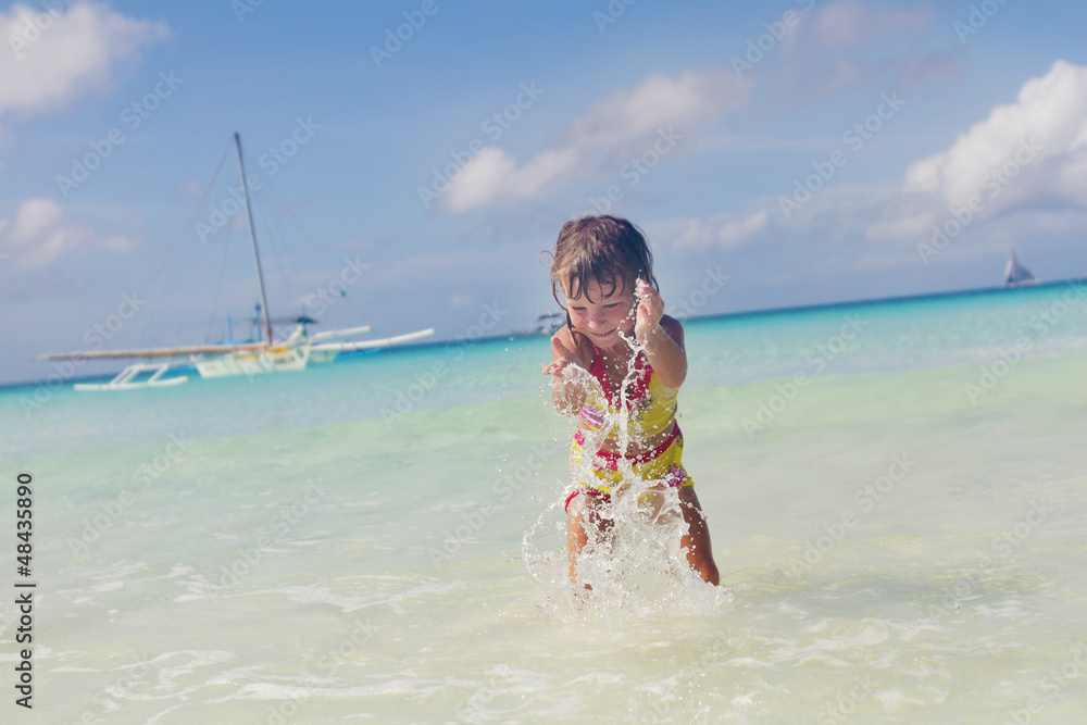 Fototapeta premium happy smiling child girl playing in water