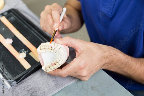 Closeup of a dental technician applying porcelain to a mold