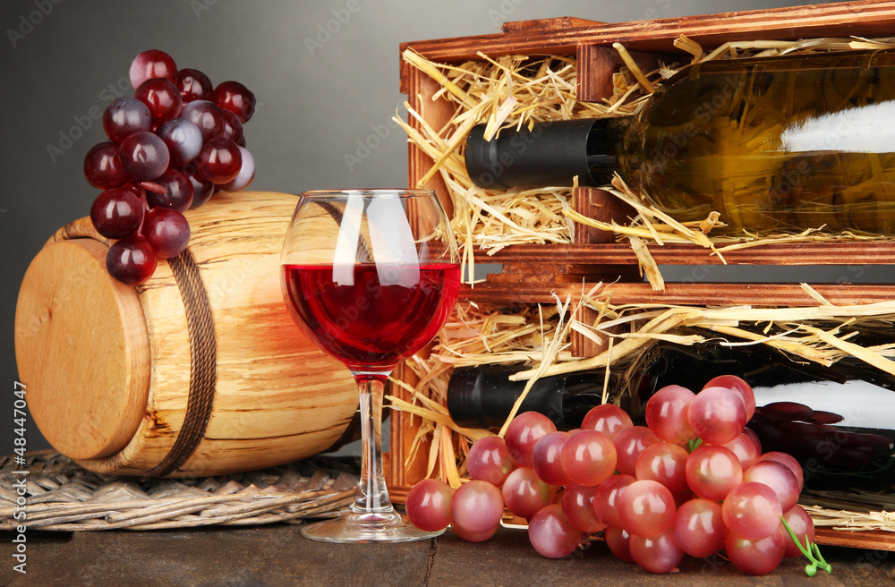 Wooden case with wine bottles, barrel, wineglass and grape