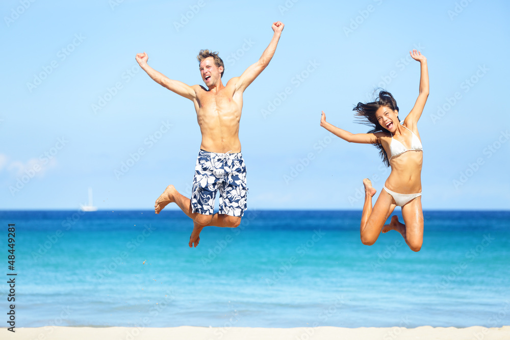 Beach people - happy couple jumping