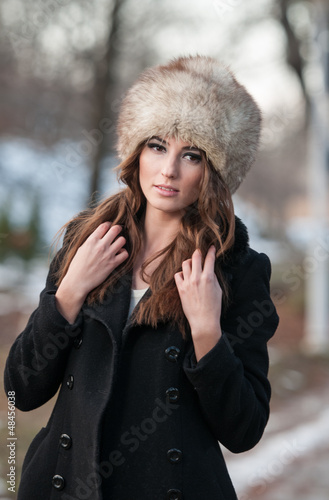 Obraz na płótnie young woman wearing coat walking down the street, cold winter w salonie