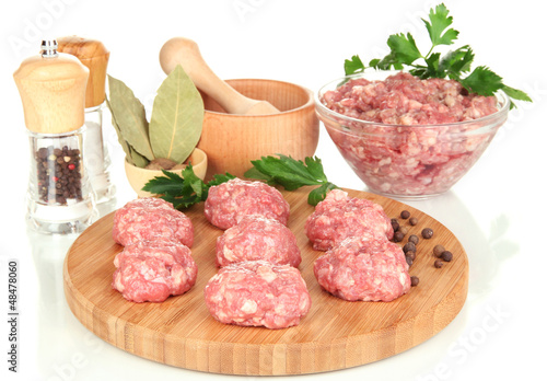 Raw meatballs with spices isolated on white