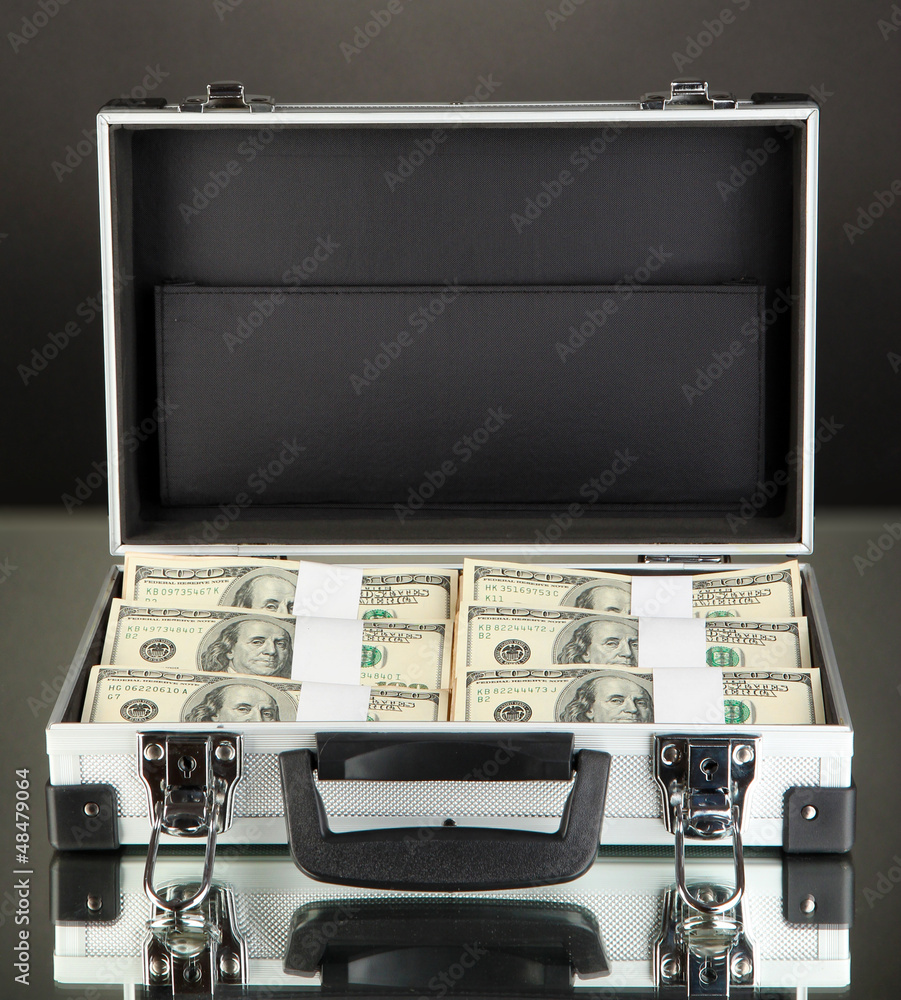 Suitcase with 100 dollar bills on black background Suitcase with 100 dollar bills on black background