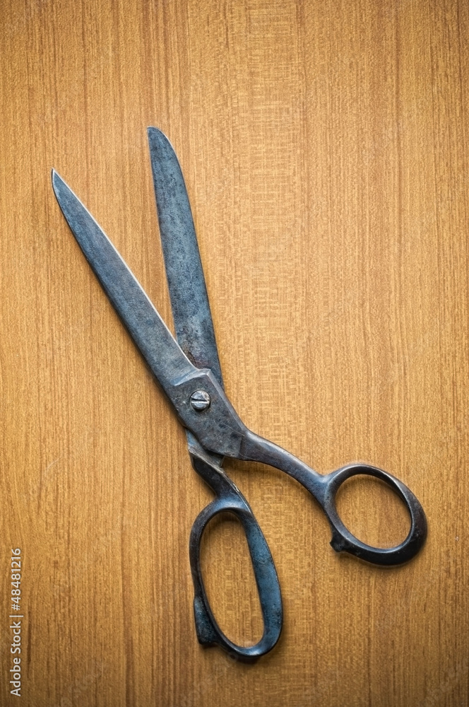 Old tailors scissors on wood background Old tailors scissors on wood background