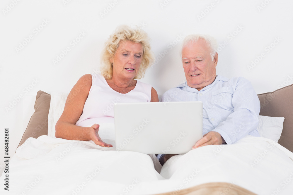 Aged couple reading or using a tablet Aged couple reading or using a tablet
