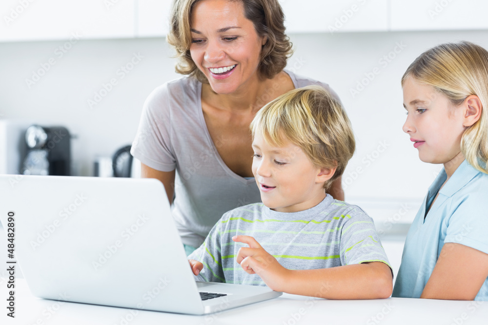 Mother using laptop with her children Mother using laptop with her children