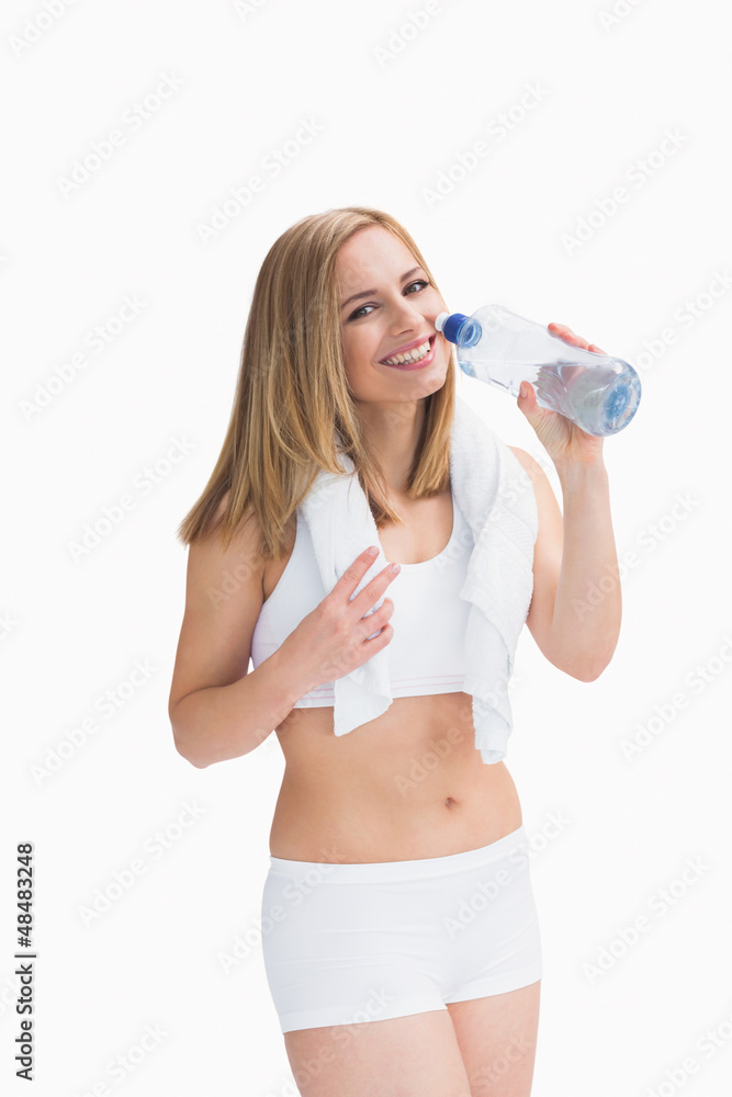 Portrait of smiling woman with towel around neck drinking water Portrait of smiling woman with towel around neck drinking water