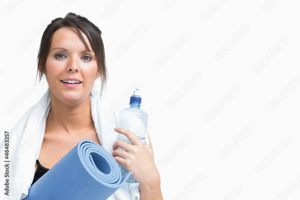 Portrait of woman holding water bottle and exercise mat Portrait of woman holding water bottle and exercise mat