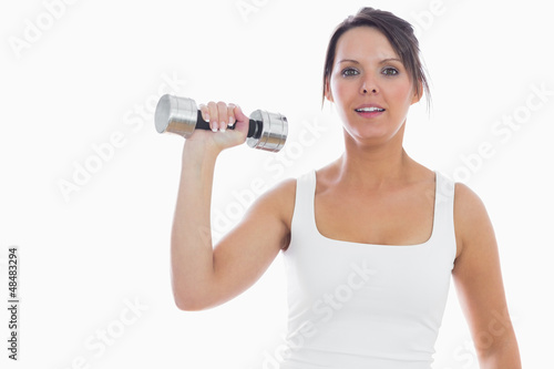Portrait of young woman exercising with dumbbell
