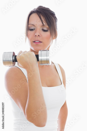 Young woman exercising with dumbbell