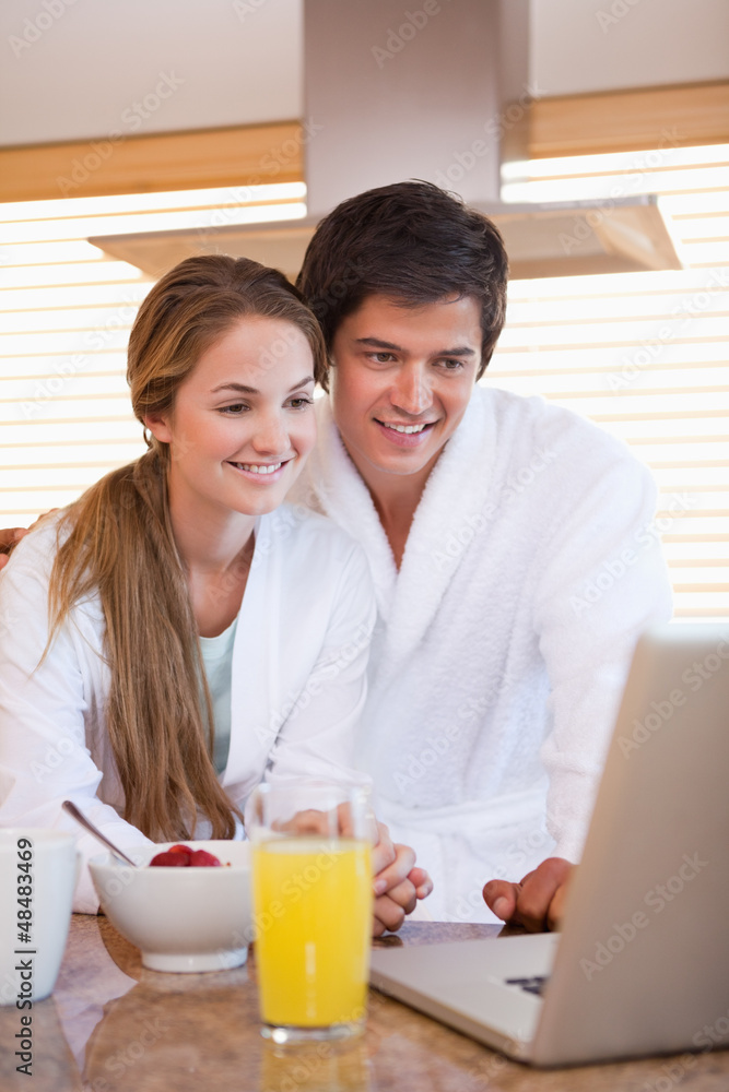 Couple using laptop over breakfast Couple using laptop over breakfast