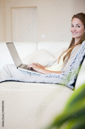 Portrait of casual woman using laptop on couch