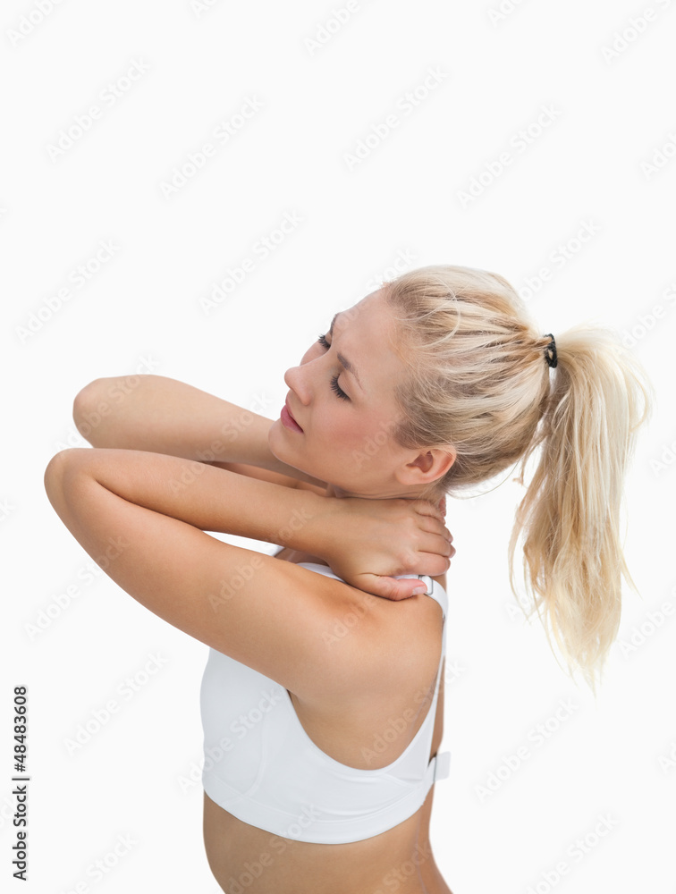 Fototapeta premium Side view of sporty young woman massaging neck