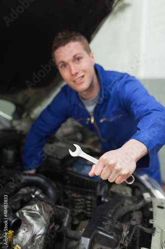 Mechanic with spanner repairing car