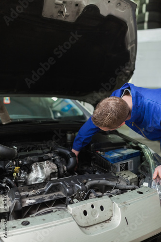 Mechanic working under bonnet of car