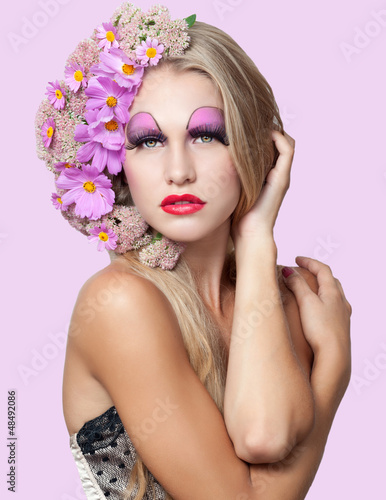 Portrait of beautiful woman with stylish makeup and pink flowers