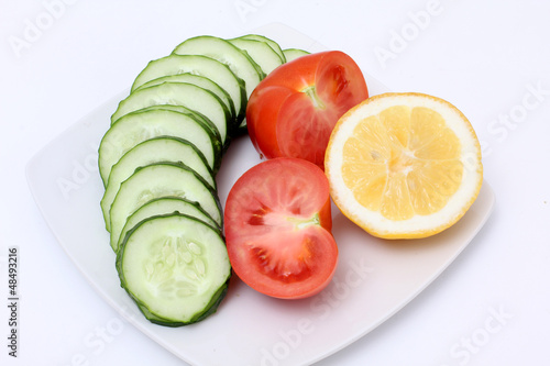 Cucumber and tomato on white plate