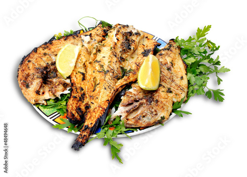 Grilled fish with greens on the plate (isolated on white backgro photo