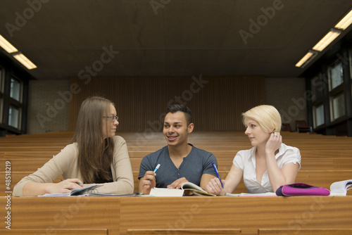 Bild auf Leinwand Ein Student und zwei Studentinnen lernen gemeinsam im Hörsaal