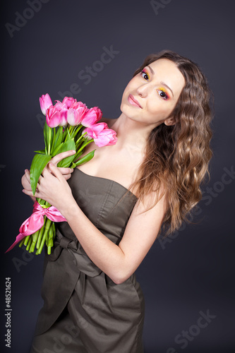 Beautiful young woman with bouquet of spring flowers photo