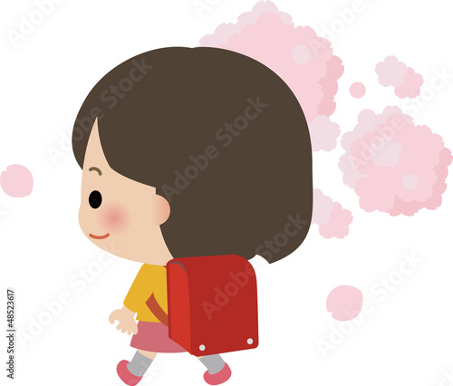 ランドセルを担いだ小学生の女の子と桜