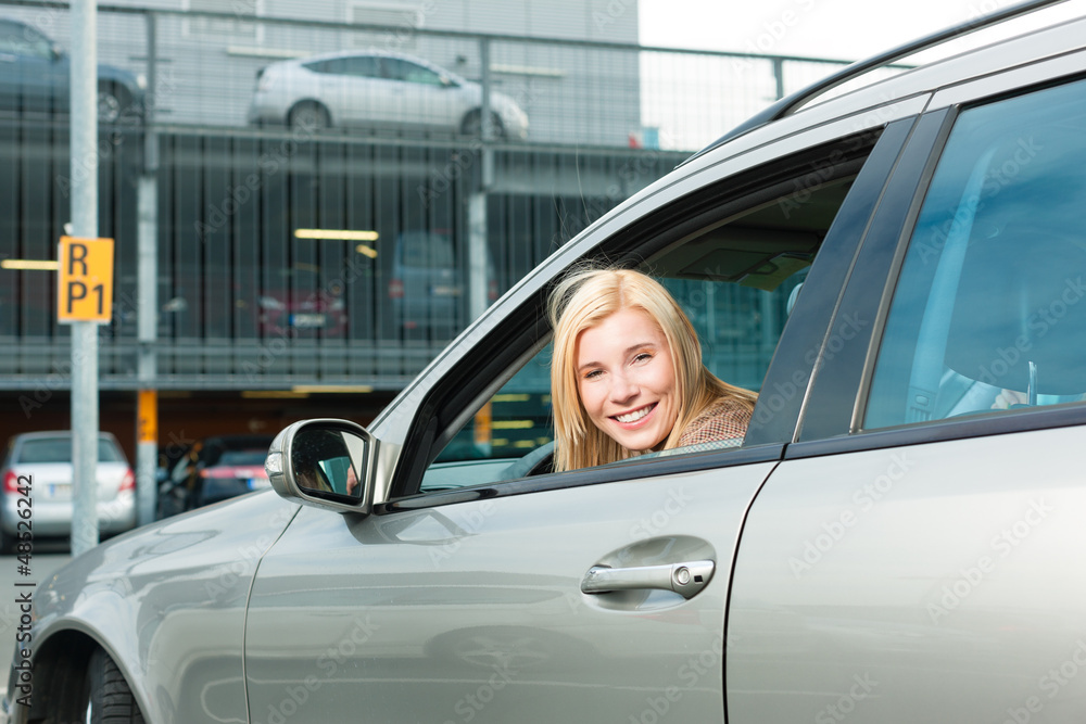 Woman back her car on a parking level Woman back her car on a parking level