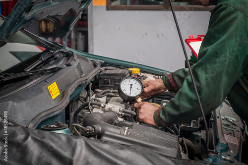 Mechanik diagnozujący usterkę silnika w warsztacie samochodowym