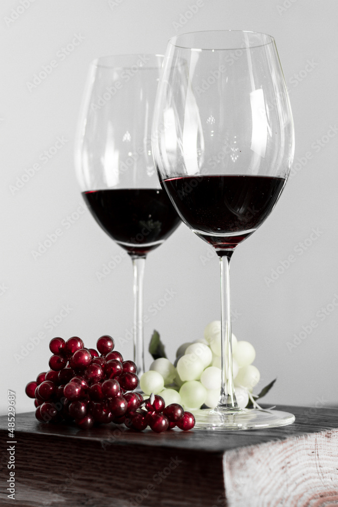 Copas de vino con uvas. Botellas de vino de fondo.
