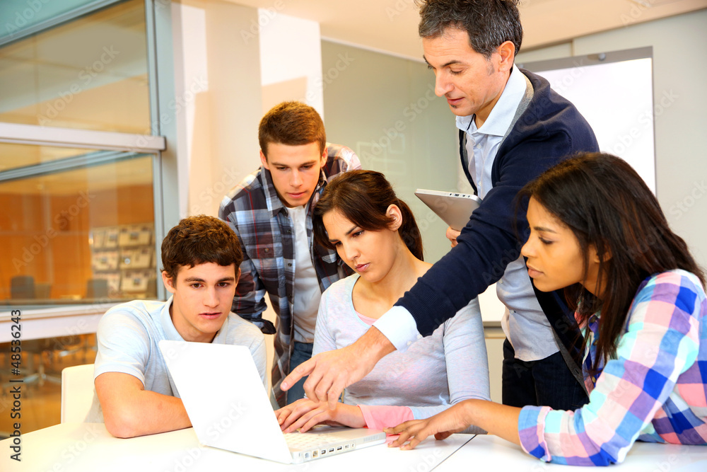 Group of students in computer training with teacher Group of students in computer training with teacher