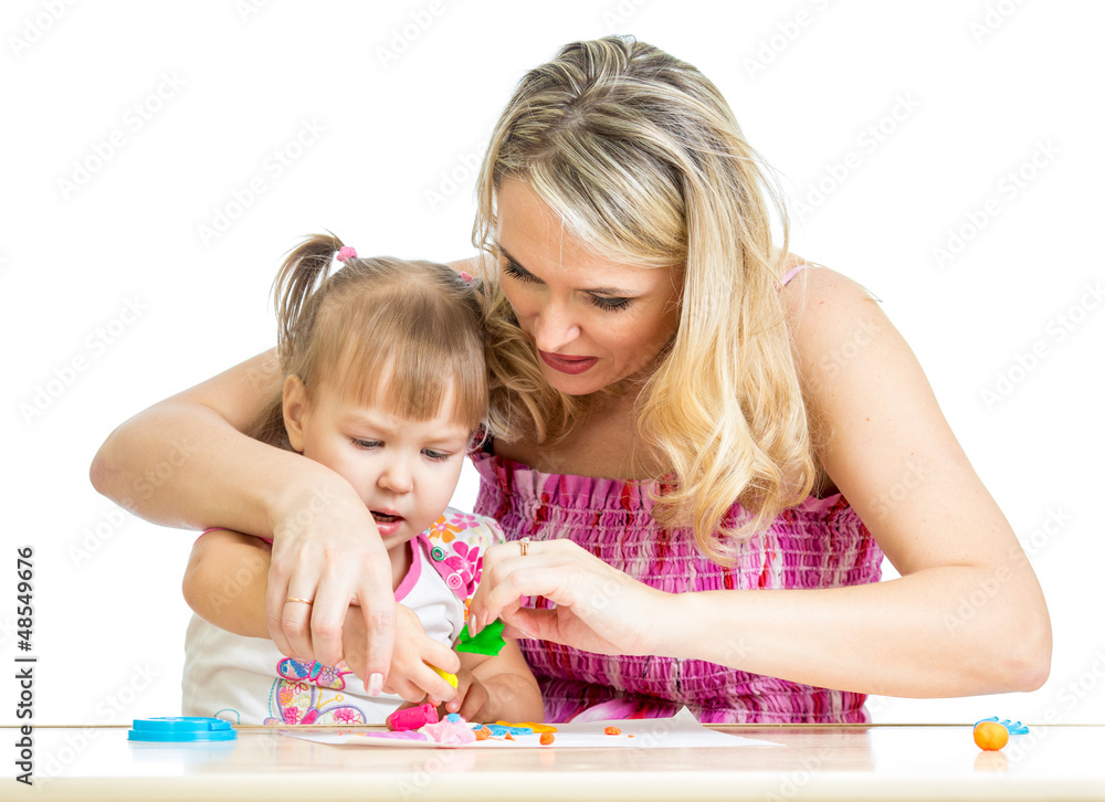 Happy little kid and mother sitting at table and playing with co Happy little kid and mother sitting at table and playing with co