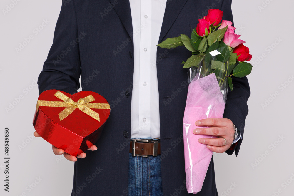 Man holding flowers and a box of chocolates Man holding flowers and a box of chocolates