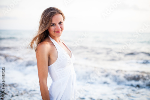 Young woman on the beach enjoying a warm summer evening © lightpoet