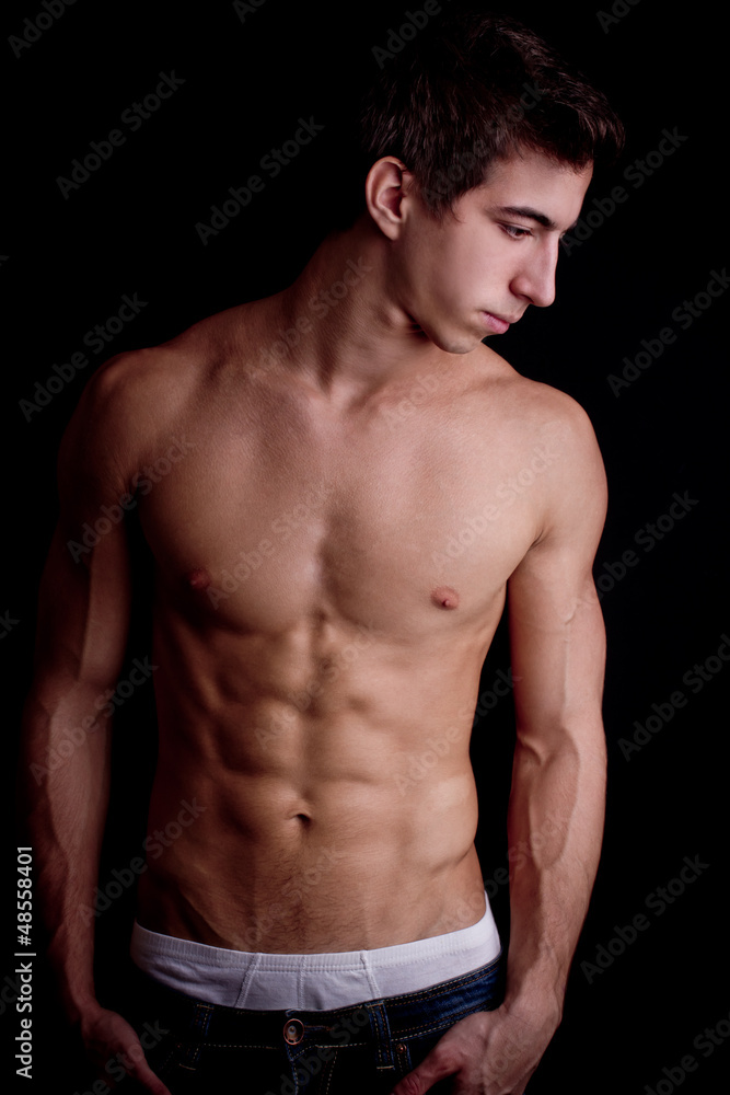 portrait of a muscular man against black background