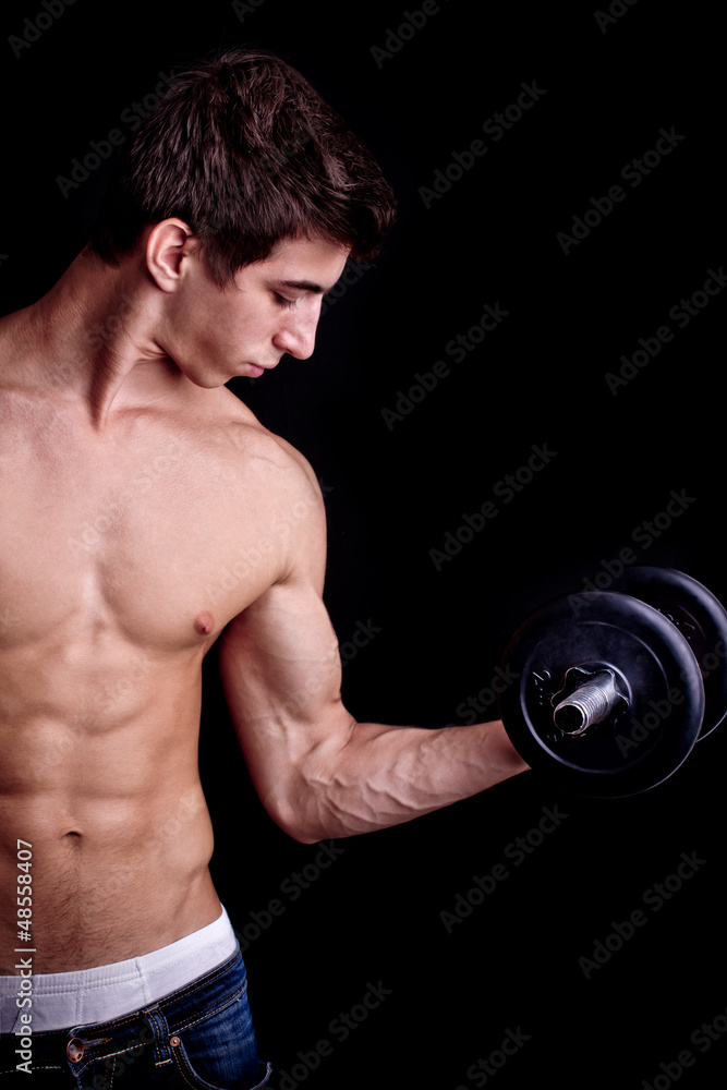 fit muscular man exercising with dumbbell on black background