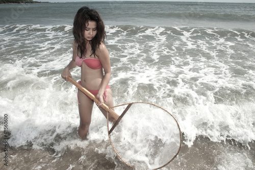 Pretty Asian woman joyfully with fishing scoop net . © topten22photo