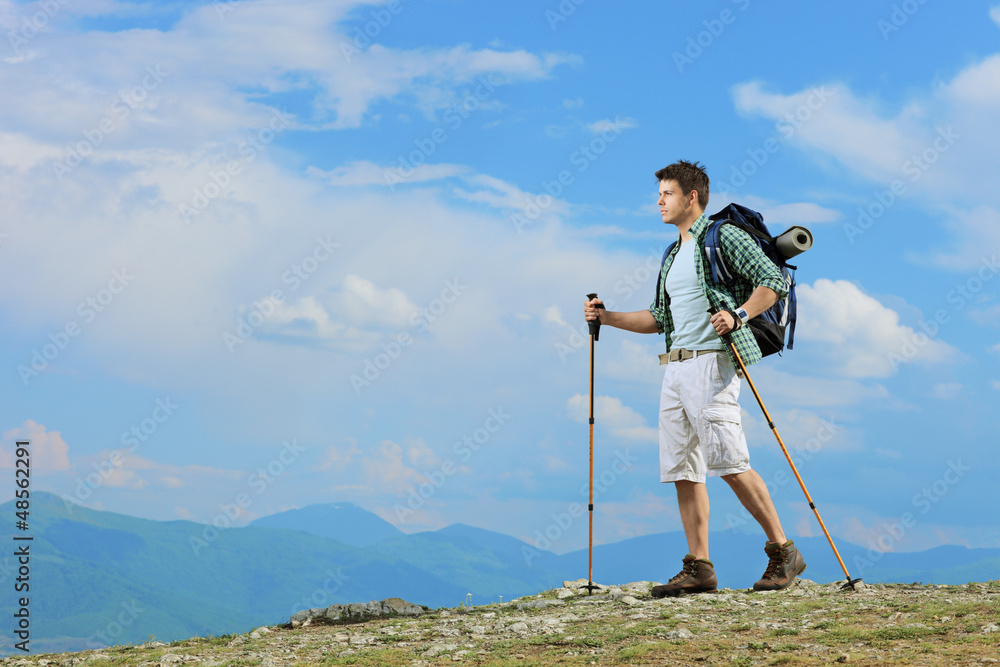 A young hiker with backpack hiking a mountain