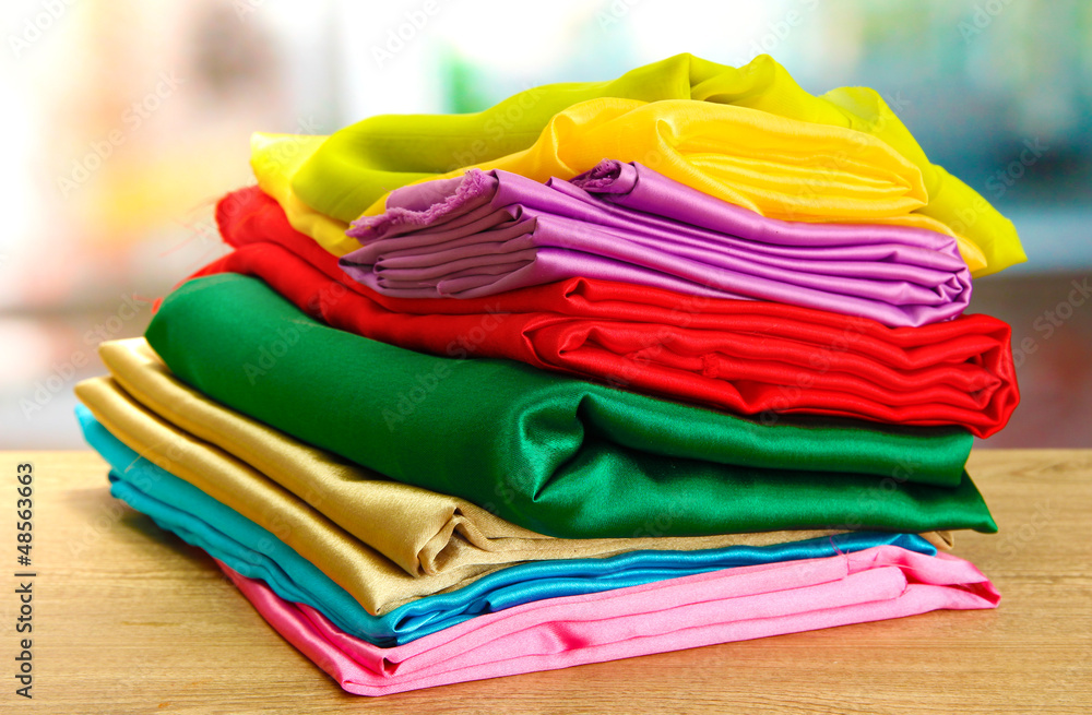 heap of cloth fabrics on wooden table heap of cloth fabrics on wooden table