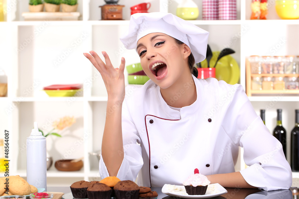 Young woman chef with cake in kitchen Young woman chef with cake in kitchen