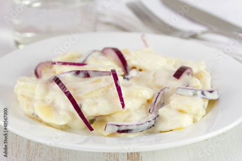 salad with potato and onion on white plate