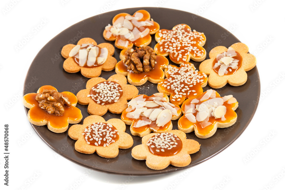 Plate with homemade butter cookies with caramel, walnut, almond