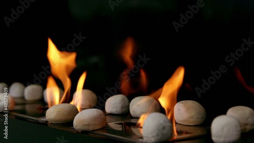 Tongues of flame go through slot in plate with stones photo