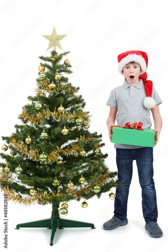 happy boy in santa hat surprised by christmas present happy boy in santa hat surprised by christmas present