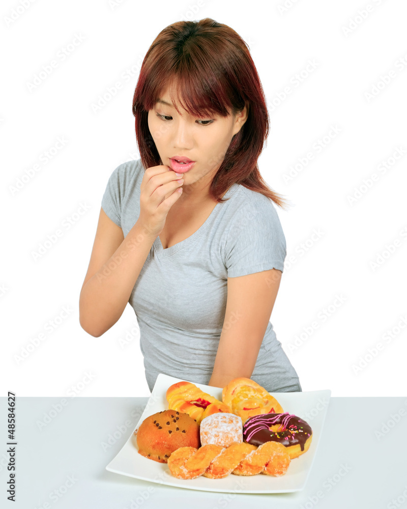 Isolated young asian woman with a donuts on the table Isolated young asian woman with a donuts on the table
